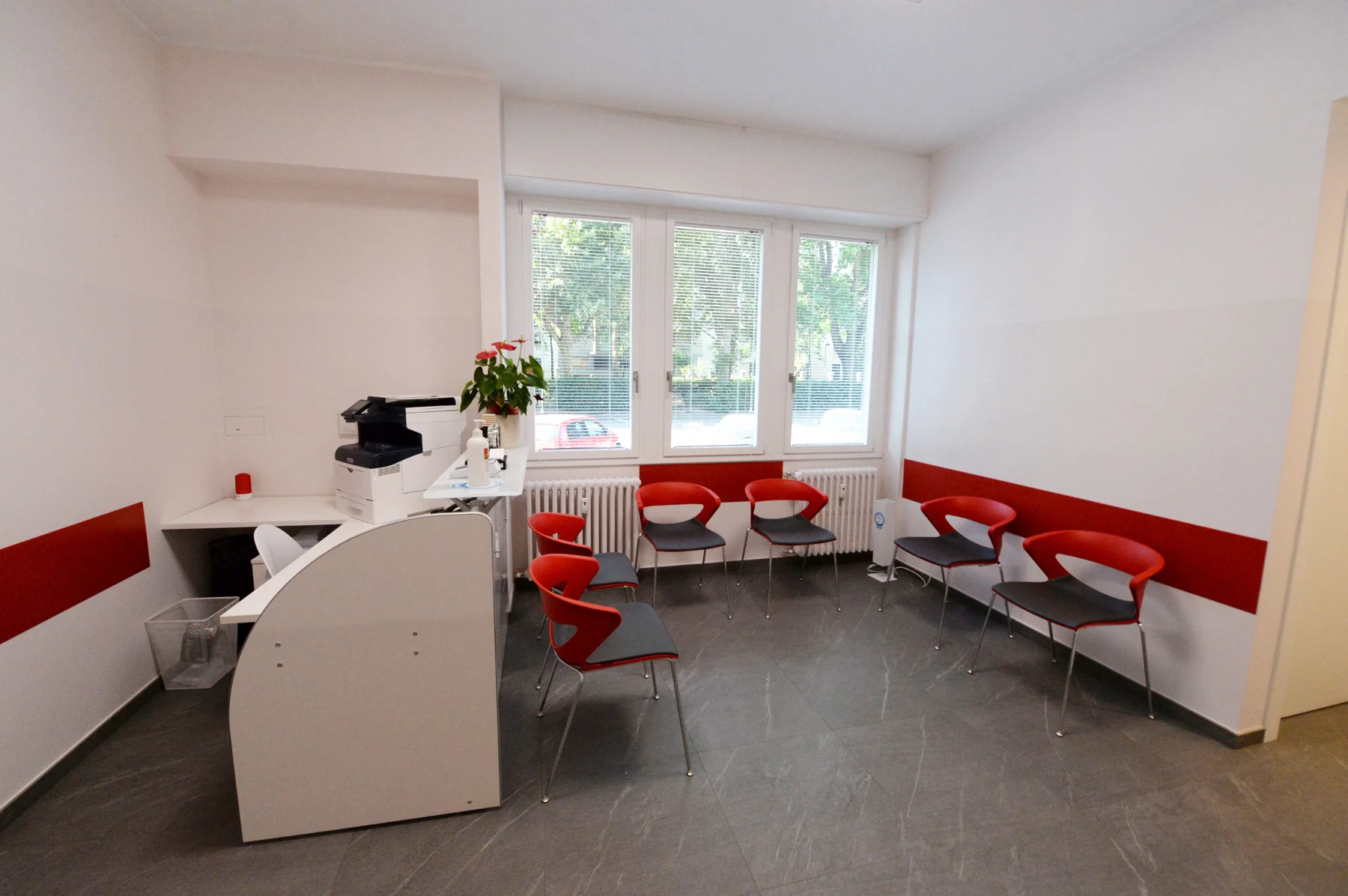 Reception con banco di accoglienza e sedute rosse